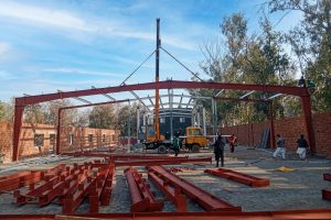 Crane lifting heavy steel beams during PEB structural assembly by M. Siddique Sons Engineering.