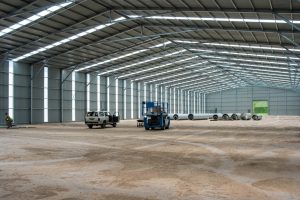 Wide interior view of a large-span pre-engineered steel warehouse shed featuring translucent roof panels and clean industrial flooring by M. Siddique Sons Engineering.